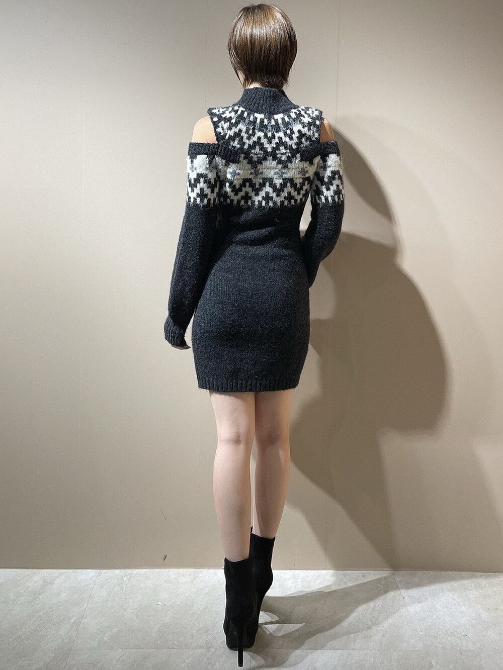 グレー系のワンピース、ブラック系のブーツを着用したレディースの秋コーディネートの4枚目の写真