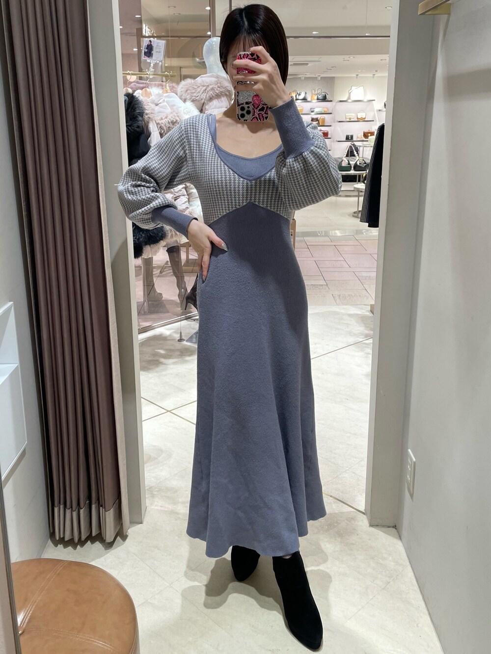 ブルー系のワンピース、ブラック系のブーツを着用したレディースの冬コーディネートの2枚目の写真