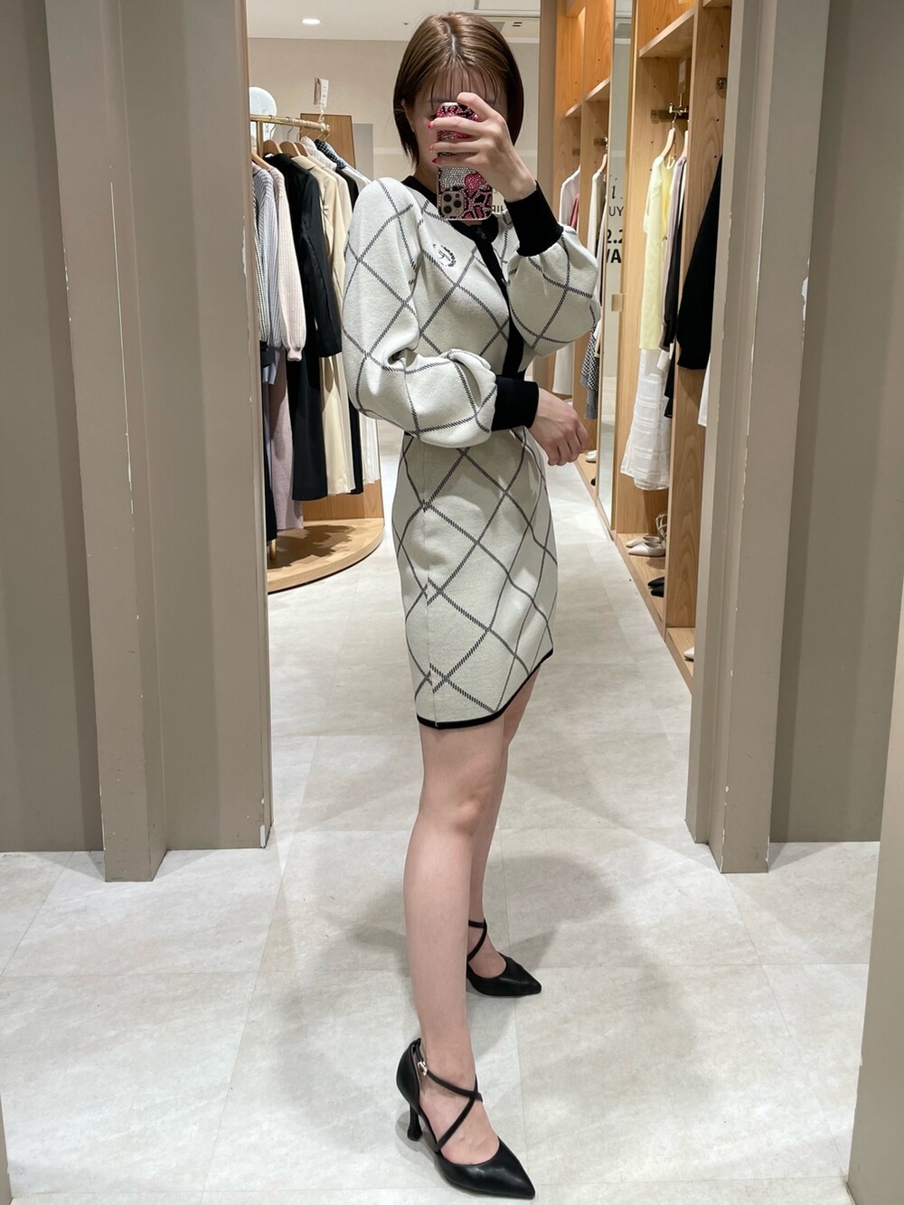 ホワイト系のカーディガン/ボレロ、ホワイト系のスカート、ブラック系のパンプスを着用したレディースの冬コーディネートの5枚目の写真