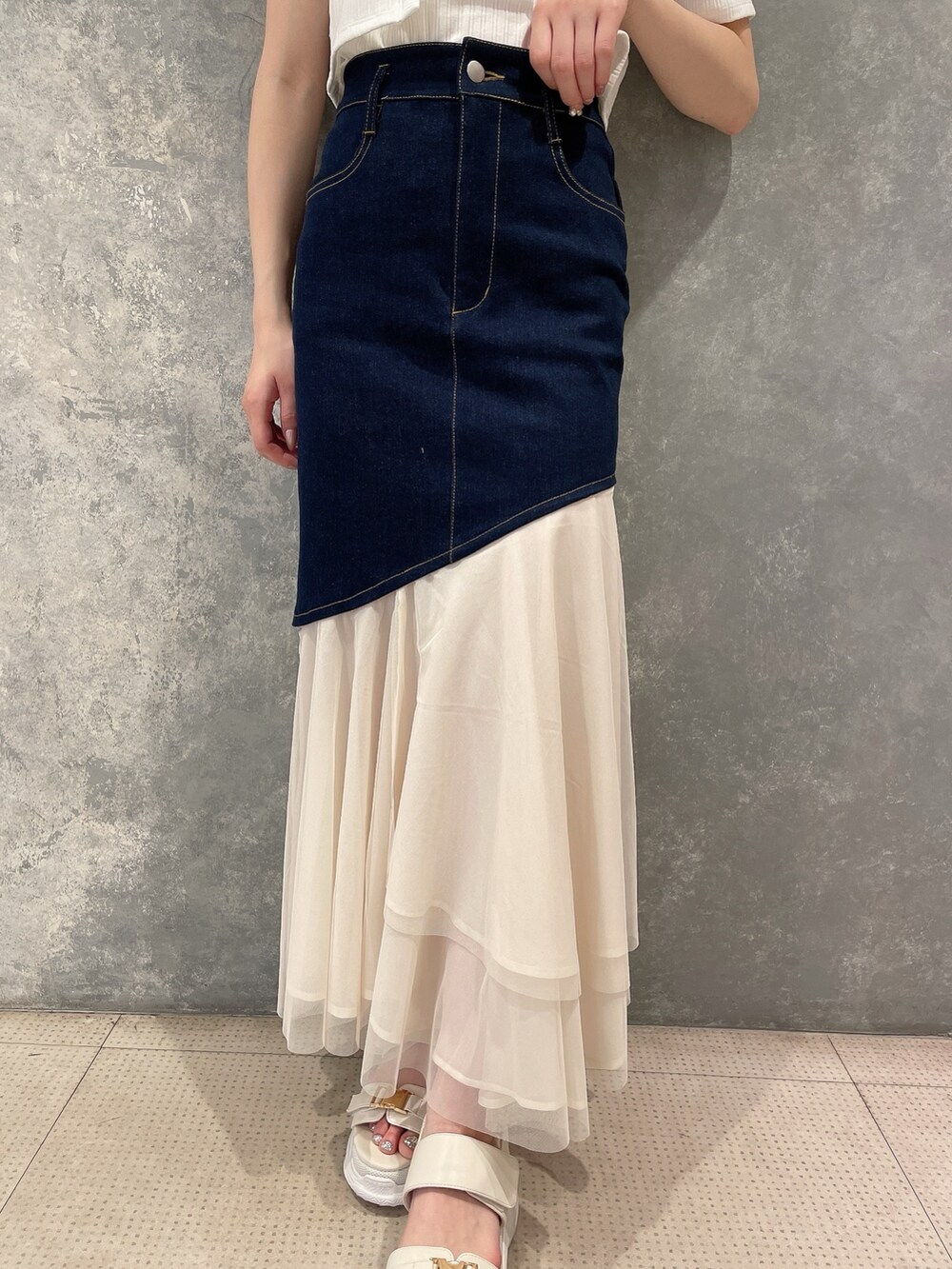 ホワイト系のカーディガン/ボレロ、ブルー系のスカート、ホワイト系のサンダルを着用したレディースの春コーディネートの4枚目の写真