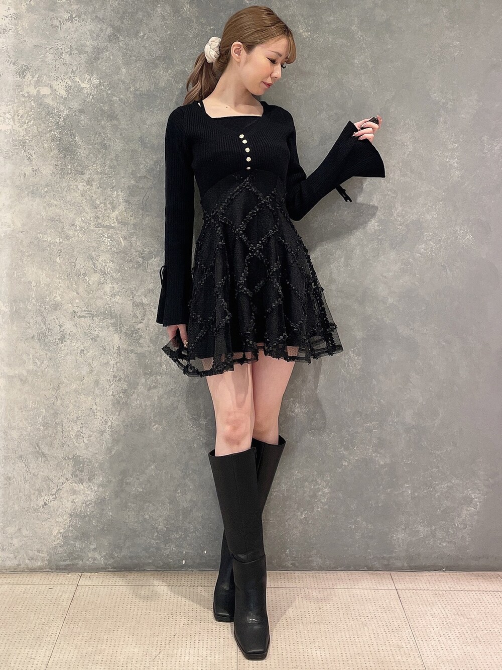 グレー系のその他アウター、ブラック系のワンピース、ブラック系のブーツを着用したレディースの秋コーディネートの4枚目の写真