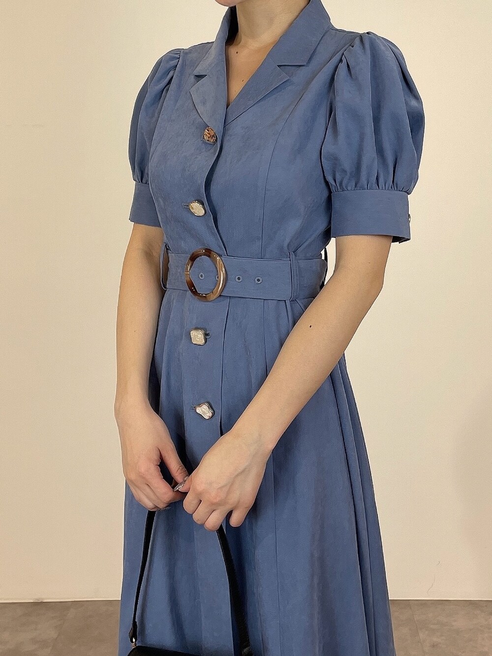 ブルー系のワンピース、ブラック系のパンプス、ブラック系のハンドバッグを着用したレディースの冬コーディネートの7枚目の写真