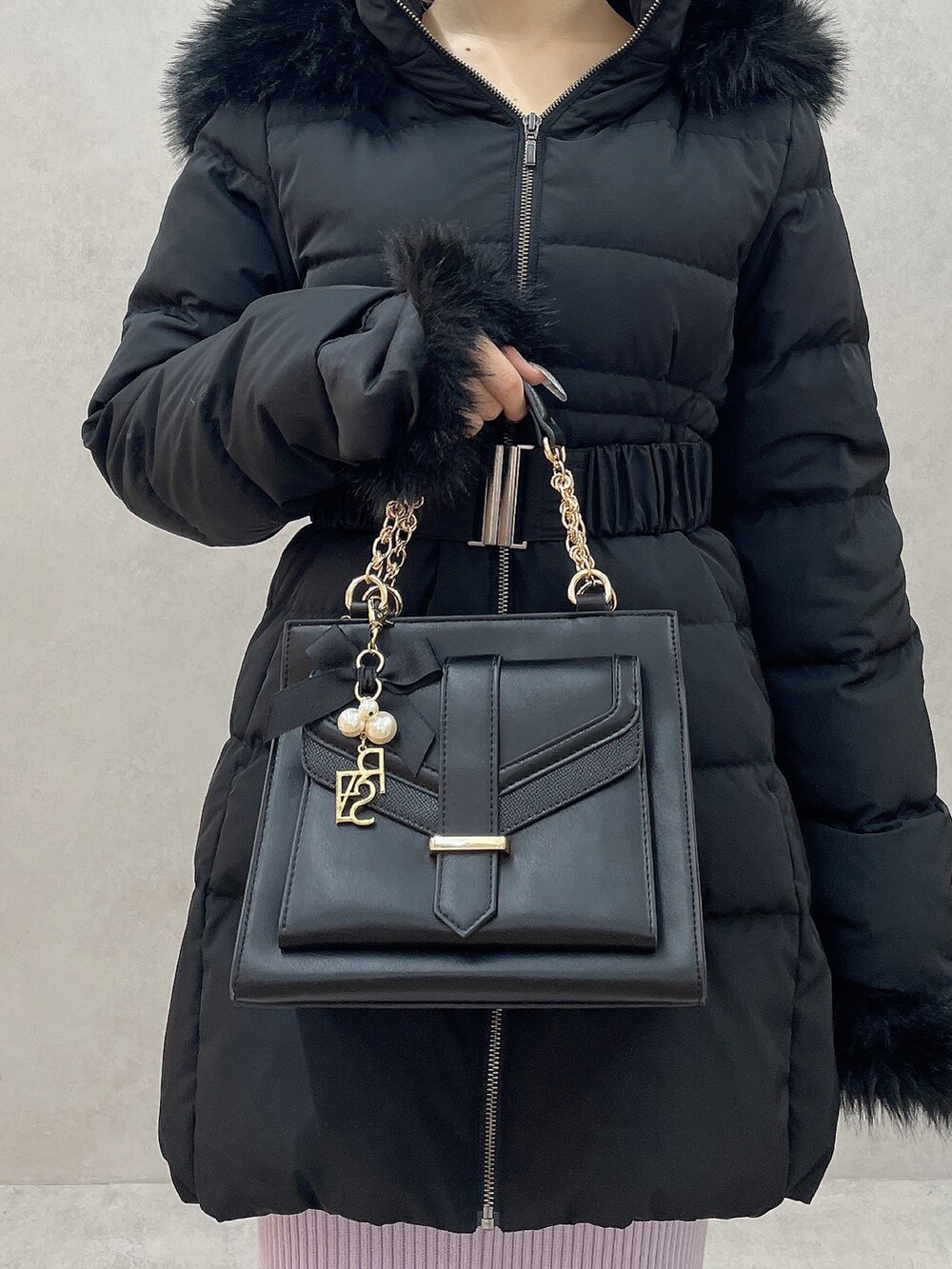 グレー系のワンピース、ブラック系のハンドバッグ、ブラック系のブーツを着用したレディースの秋コーディネートの8枚目の写真