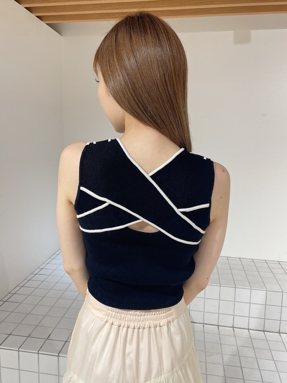 ブラック系のパンプス、ホワイト系のスカート、ブラック系のタンクトップを着用したレディースの夏コーディネートの6枚目の写真