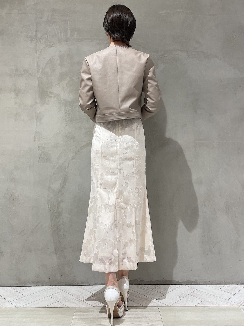 ホワイト系のパンプス、ホワイト系のスカート、ブラック系のニット/セーターを着用したレディースの冬コーディネートの6枚目の写真