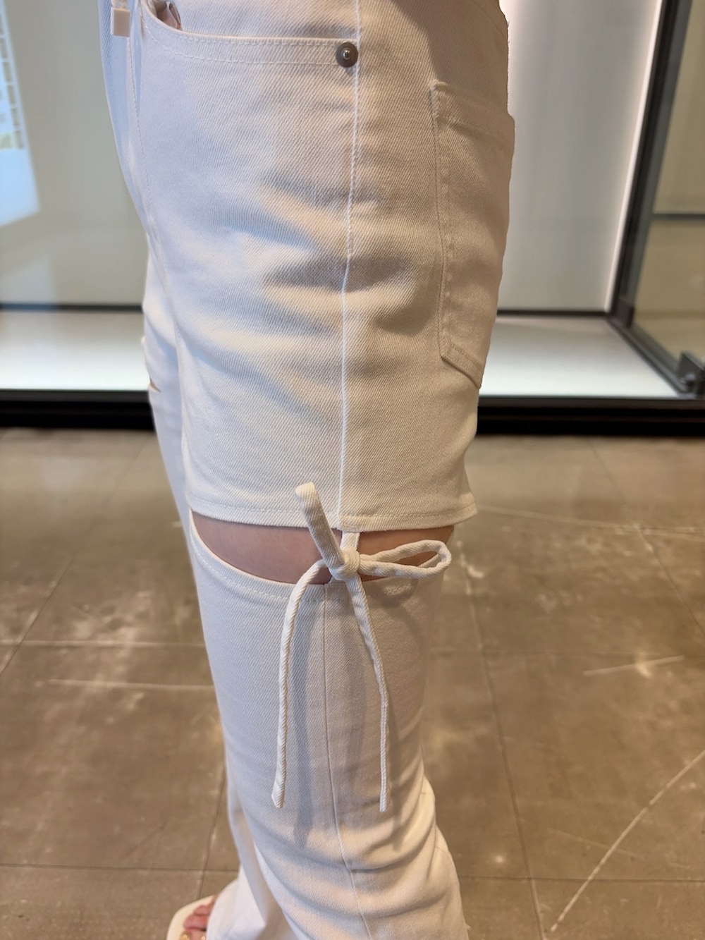 グレー系のTシャツ/カットソー、ホワイト系のデニムパンツ、ホワイト系のサンダルを着用したレディースの夏コーディネートの9枚目の写真