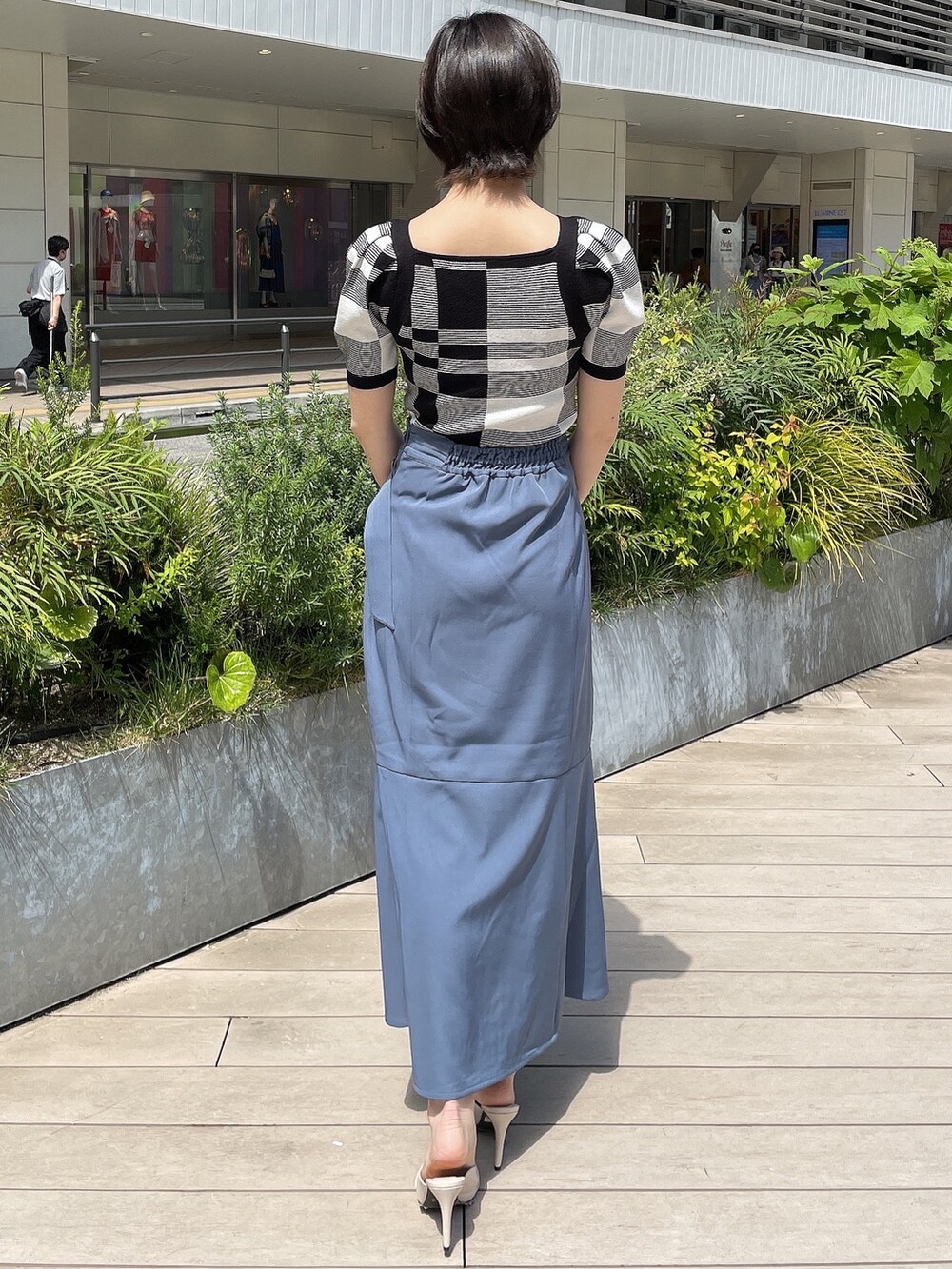 その他のニット/セーター、ブルー系のスカート、ホワイト系のハンドバッグを着用したレディースの春コーディネートの3枚目の写真