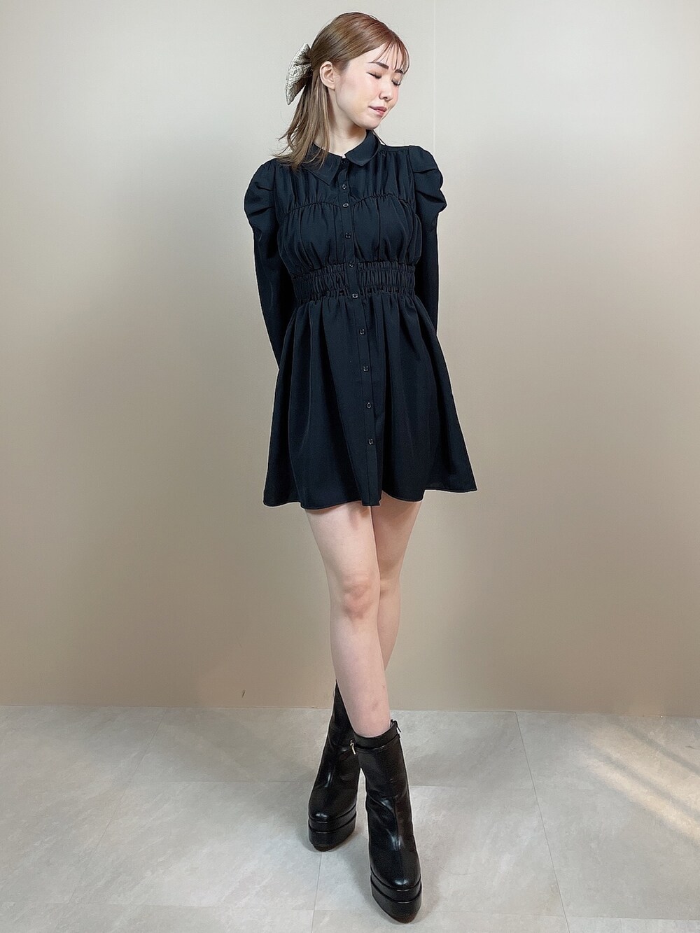 ブラック系のワンピース、ブラック系のブーツ、ベージュ系のバレッタ/ヘアクリップを着用したレディースの冬コーディネートの2枚目の写真