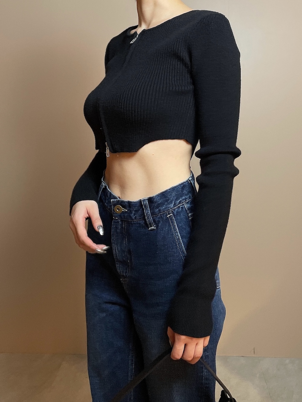 ブラック系のニット/セーター、ブルー系のデニムパンツ、ブラック系のハンドバッグを着用したレディースの冬コーディネートの8枚目の写真