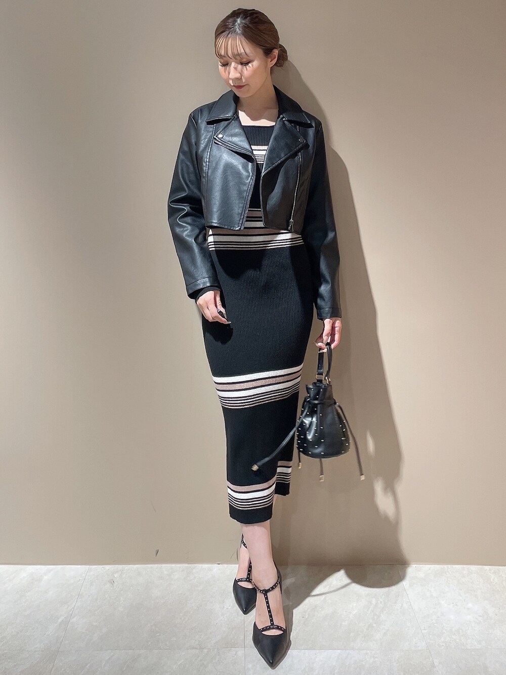ブラック系のライダースジャケット、その他のワンピース、ブラック系のハンドバッグを着用したレディースの秋コーディネートの2枚目の写真