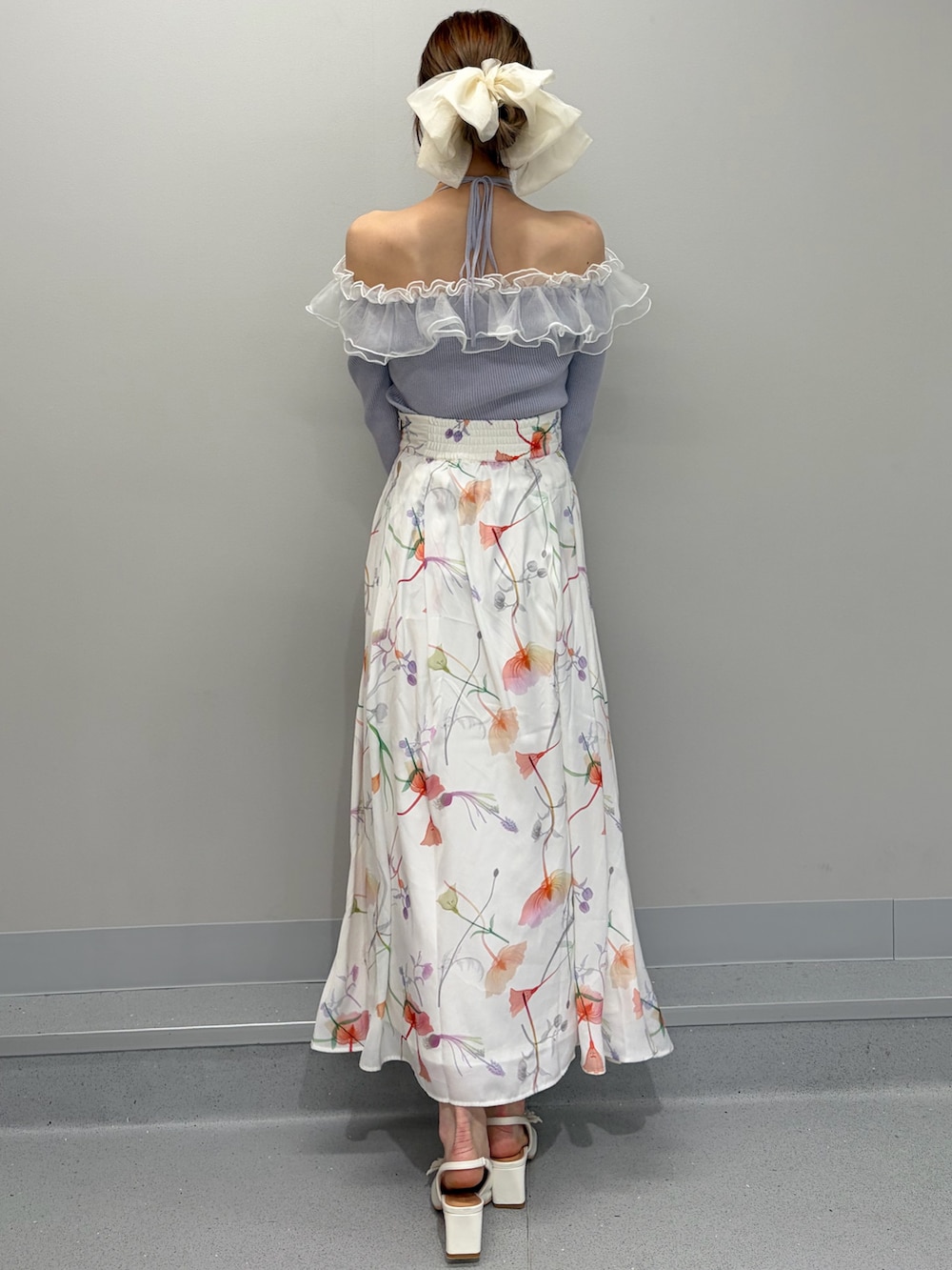 ホワイト系のテーラードジャケット、パープル系のニット/セーター、ホワイト系のスカートを着用したレディースの冬コーディネートの7枚目の写真