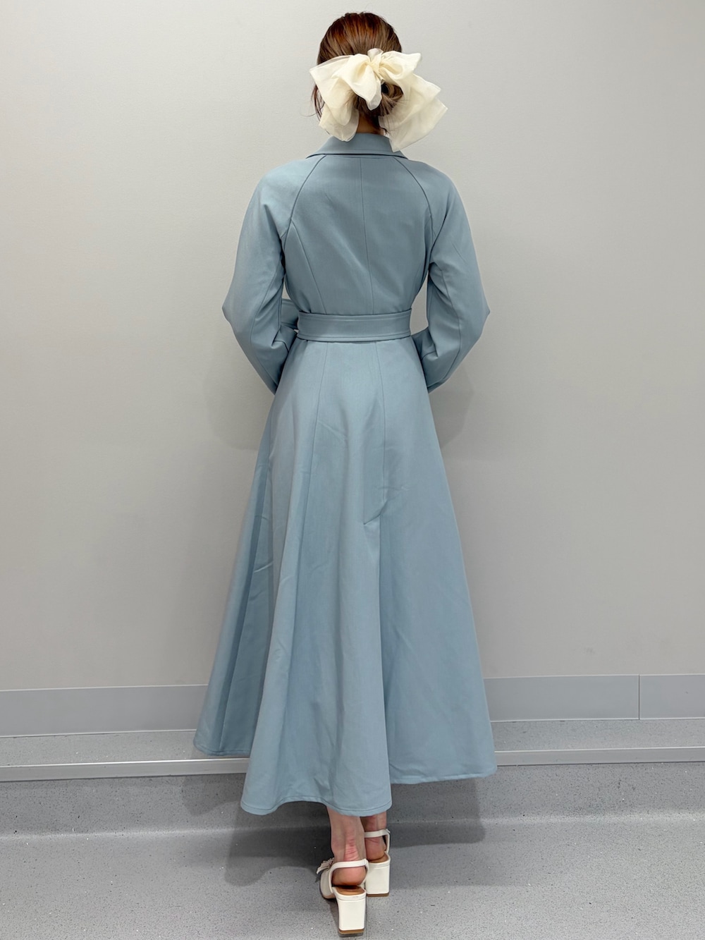 ブルー系のトレンチコート、ホワイト系のパンプス、ホワイト系のバレッタ/ヘアクリップを着用したレディースの冬コーディネートの6枚目の写真