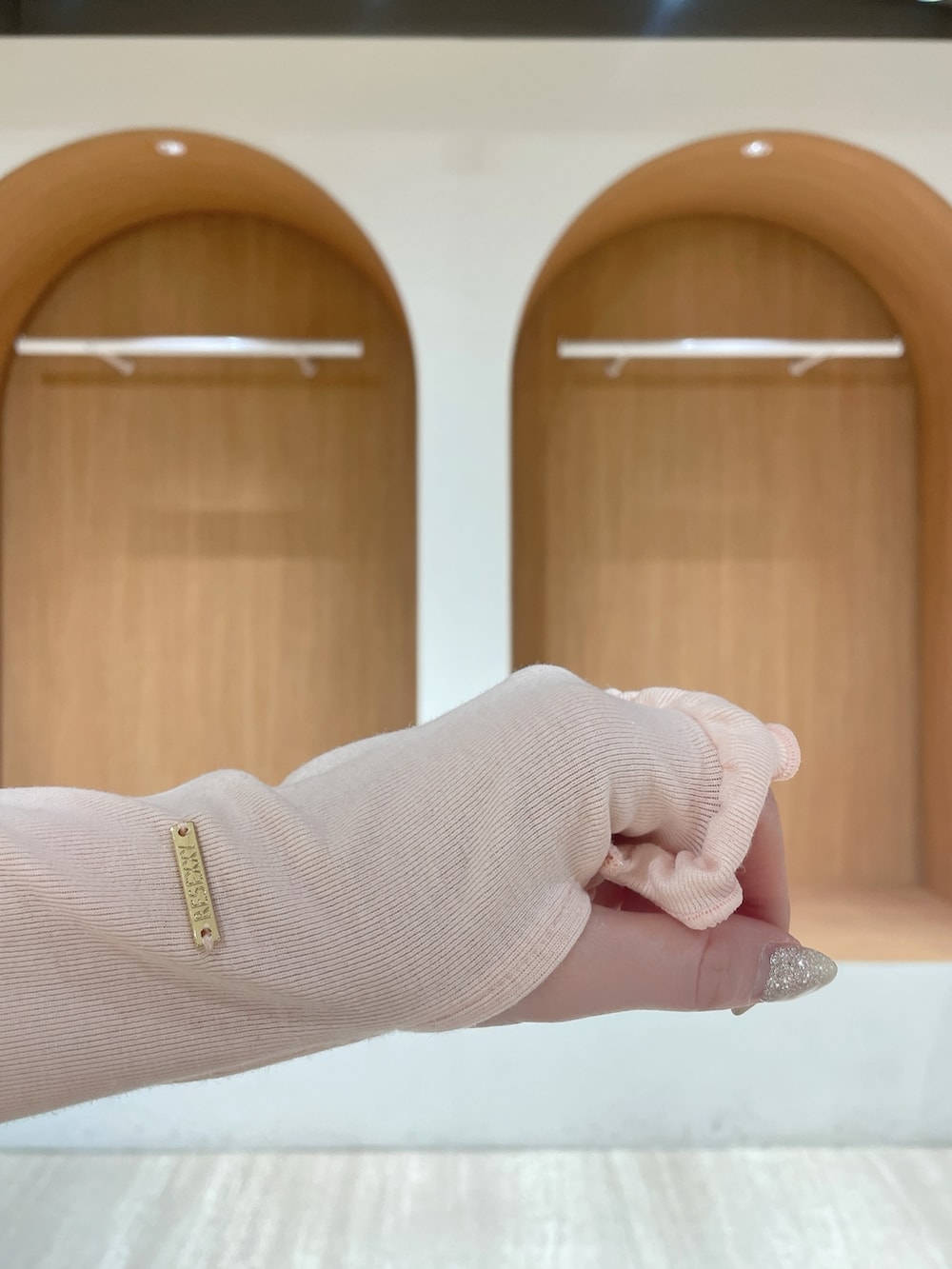 ピンク系のパーカー、ブルー系のデニムパンツ、ホワイト系のサンダルを着用したレディースの春コーディネートの5枚目の写真