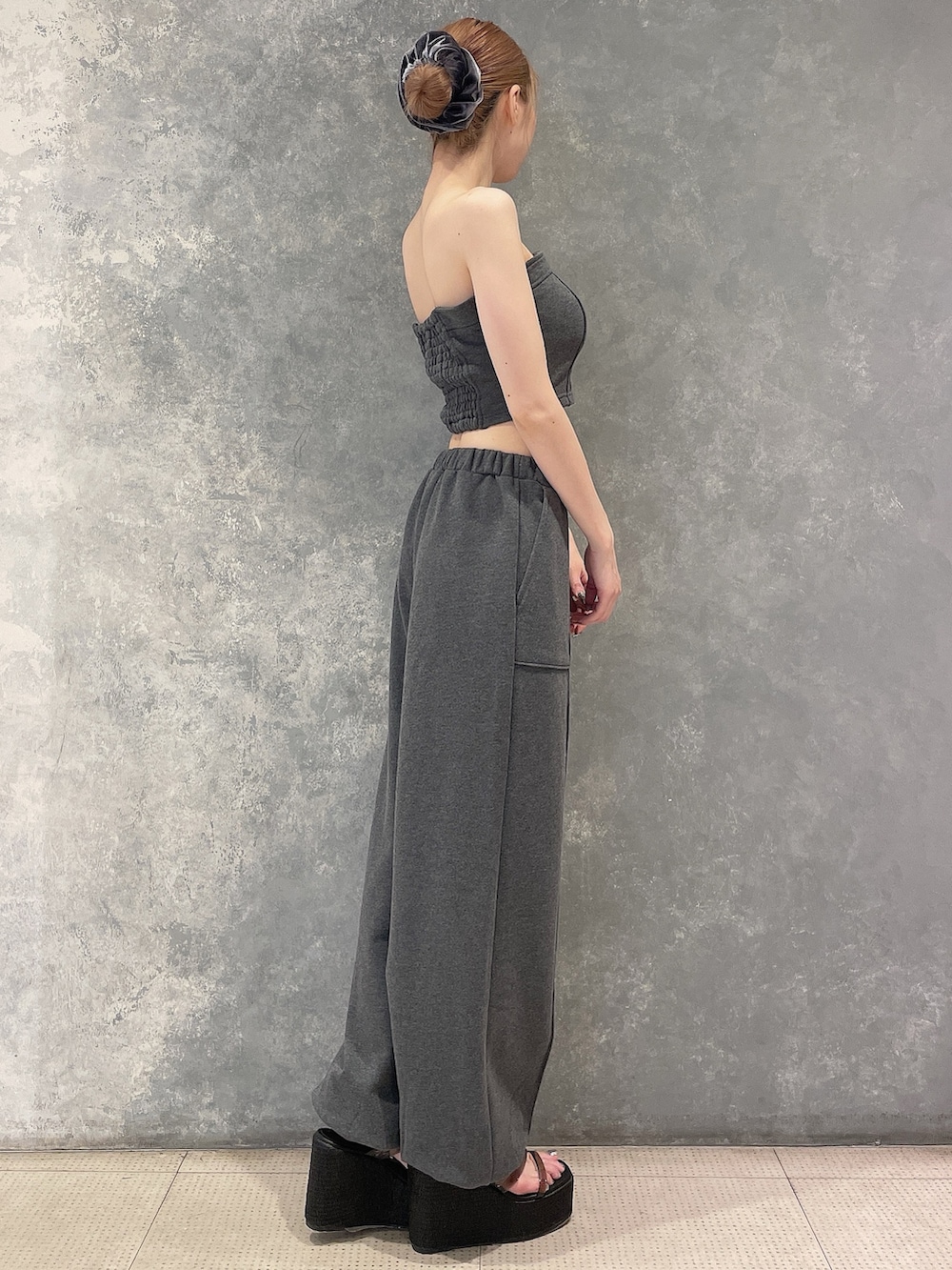 グレー系のキャミソール、グレー系のスウェットパンツ、ブラック系のサンダルを着用したレディースの夏コーディネートの3枚目の写真