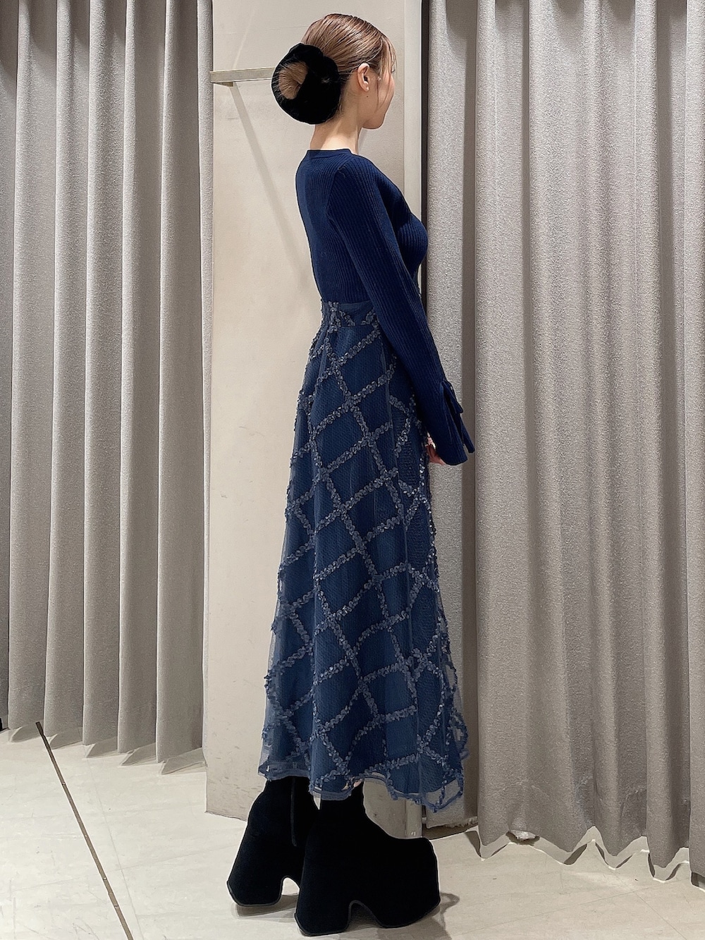 ブルー系のワンピース、ブラック系のブーツ、ブラック系のシュシュを着用したレディースの秋コーディネートの4枚目の写真