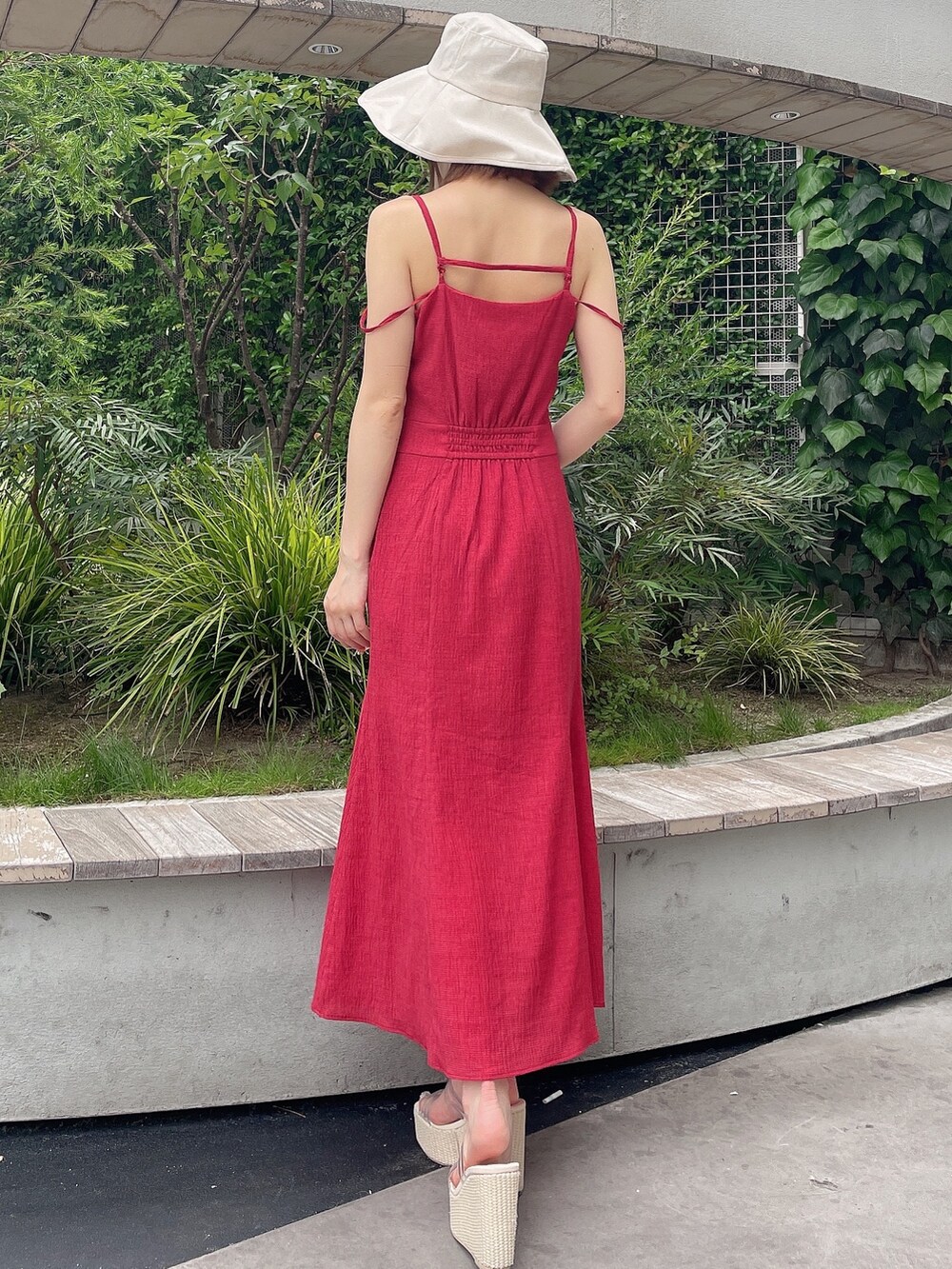 レッド系のワンピース、ホワイト系のサンダル、ホワイト系のハットを着用したレディースの夏コーディネートの4枚目の写真