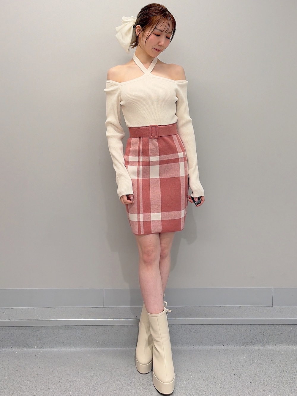 オレンジ系のワンピース、ホワイト系のブーツ、ホワイト系のバレッタ/ヘアクリップを着用したレディースの冬コーディネートの2枚目の写真