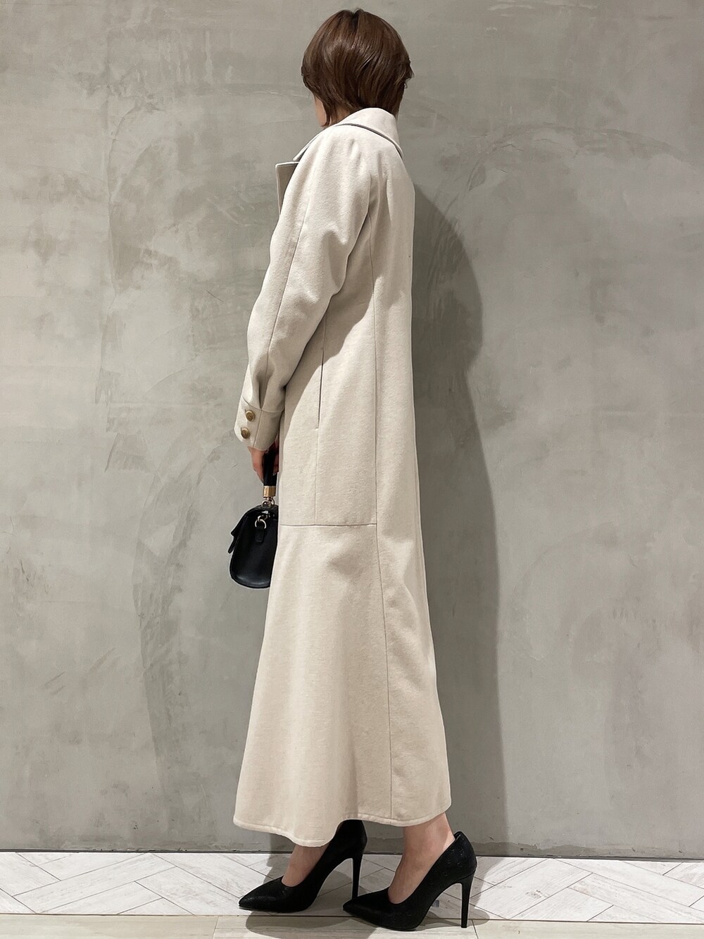 ベージュ系のその他アウター、グレー系のワンピース、ブラック系のハンドバッグを着用したレディースの冬コーディネートの3枚目の写真