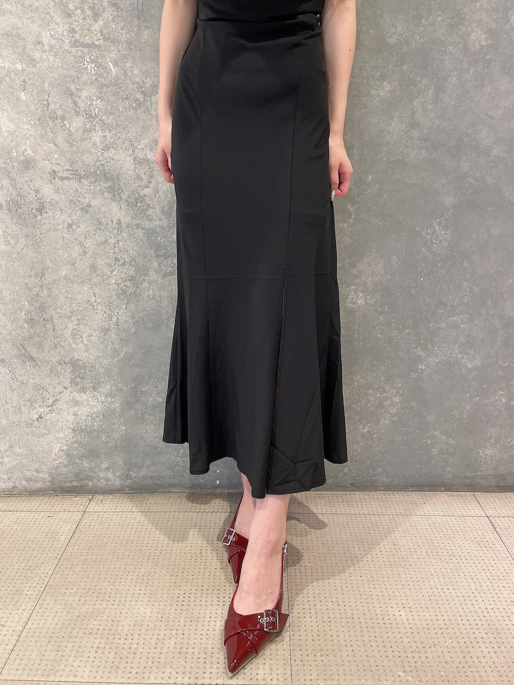 ブラック系のワンピース、レッド系のパンプス、グレー系のシュシュを着用したレディースの夏コーディネートの7枚目の写真