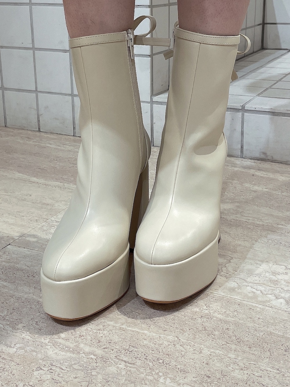 ブラック系のニット/セーター、ブルー系のデニムパンツ、ホワイト系のブーツを着用したレディースの冬コーディネートの8枚目の写真