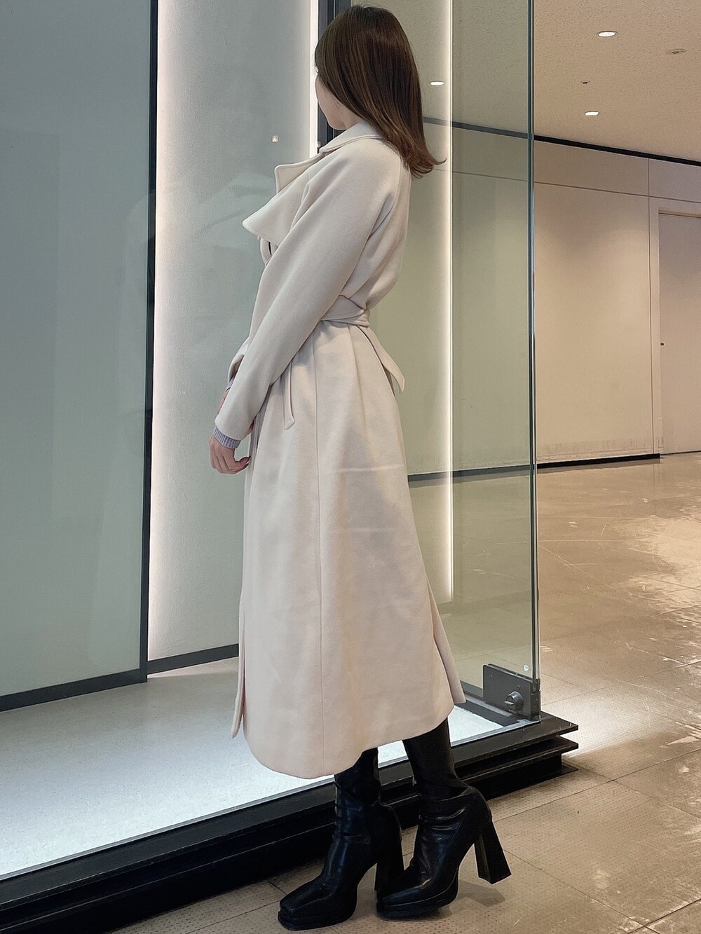 ホワイト系のその他アウター、ブラック系のブーツを着用したレディースの冬コーディネートの2枚目の写真