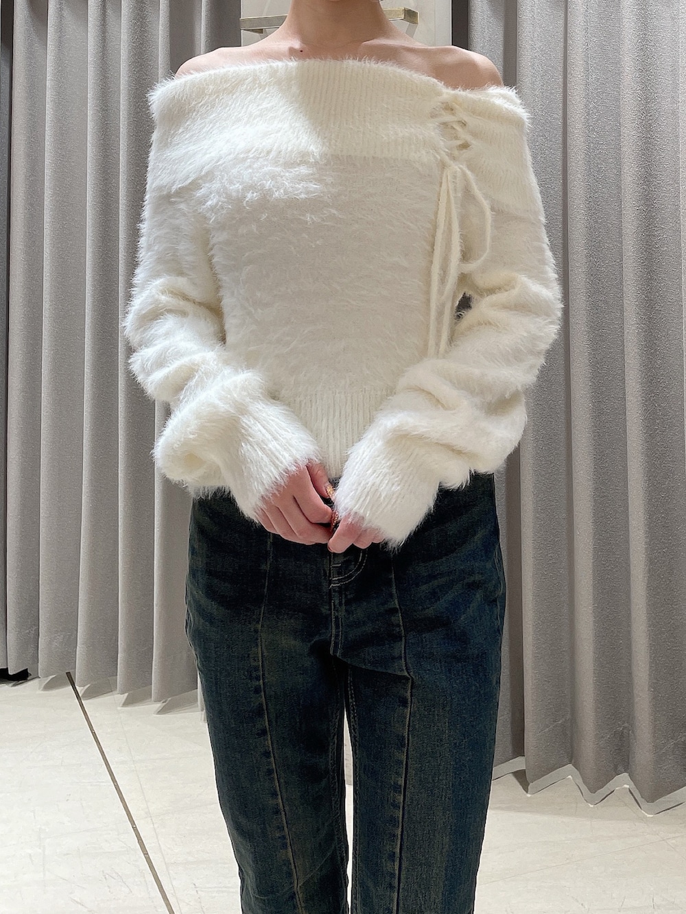 ホワイト系のニット/セーター、ブルー系のデニムパンツ、ブラック系のブーツを着用したレディースの秋コーディネートの7枚目の写真