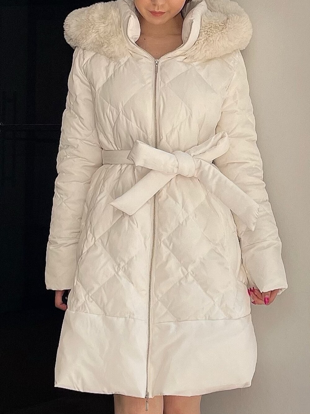 ベージュ系のブーツ、ホワイト系のダウンジャケット/コートを着用したレディースの夏コーディネートの6枚目の写真