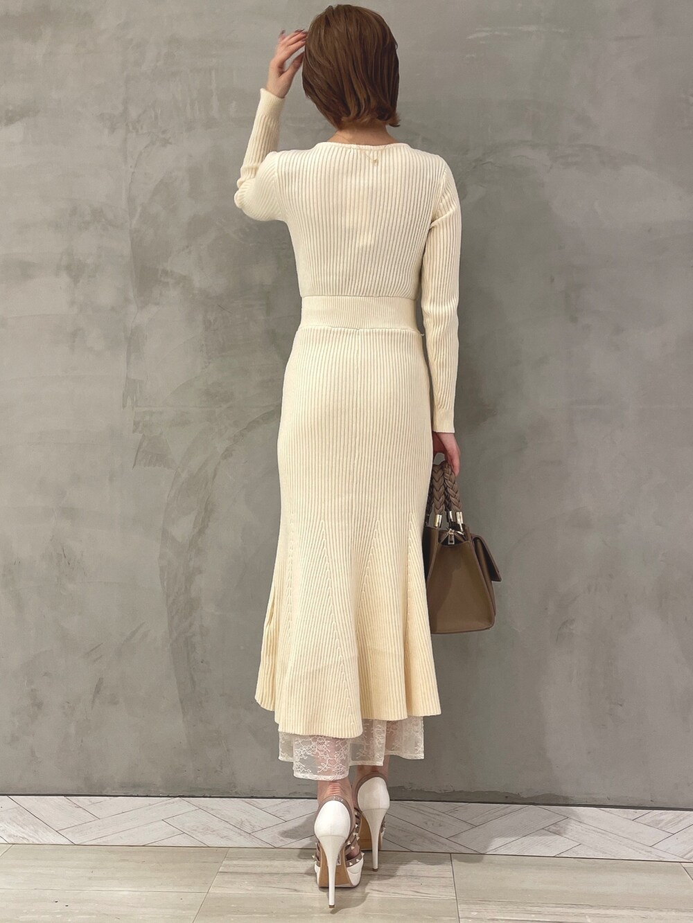 ホワイト系のワンピース、ホワイト系のパンプス、ブラウン系のハンドバッグを着用したレディースの秋コーディネートの4枚目の写真