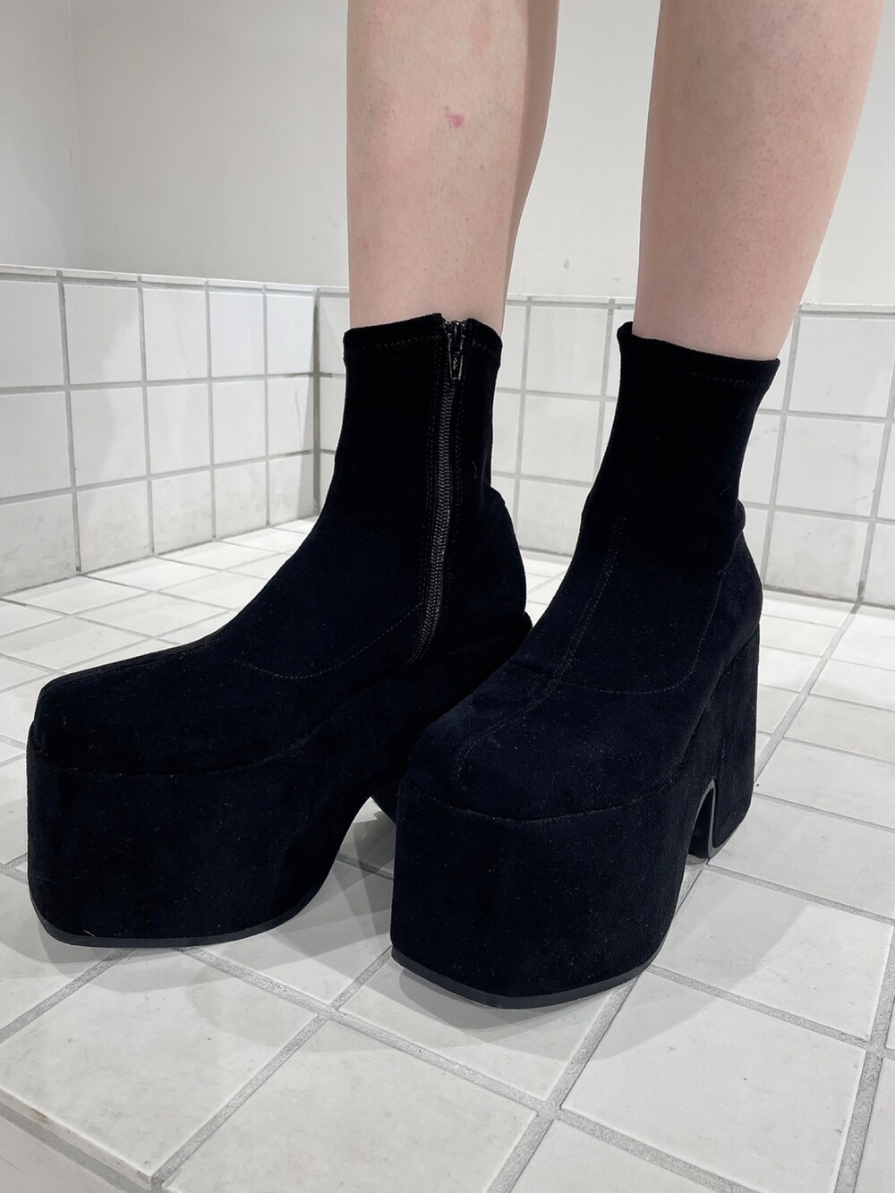 ブルー系のデニムパンツ、ブラック系のニット/セーター、ブラック系のブーツを着用したレディースの秋コーディネートの7枚目の写真