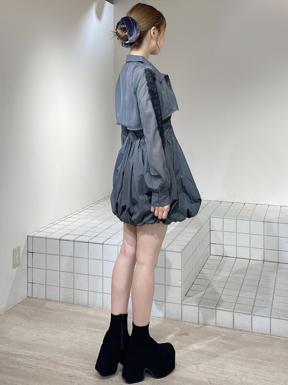 グレー系のワンピース、ブラック系のブーツ、グレー系のシュシュを着用したレディースの秋コーディネートの3枚目の写真