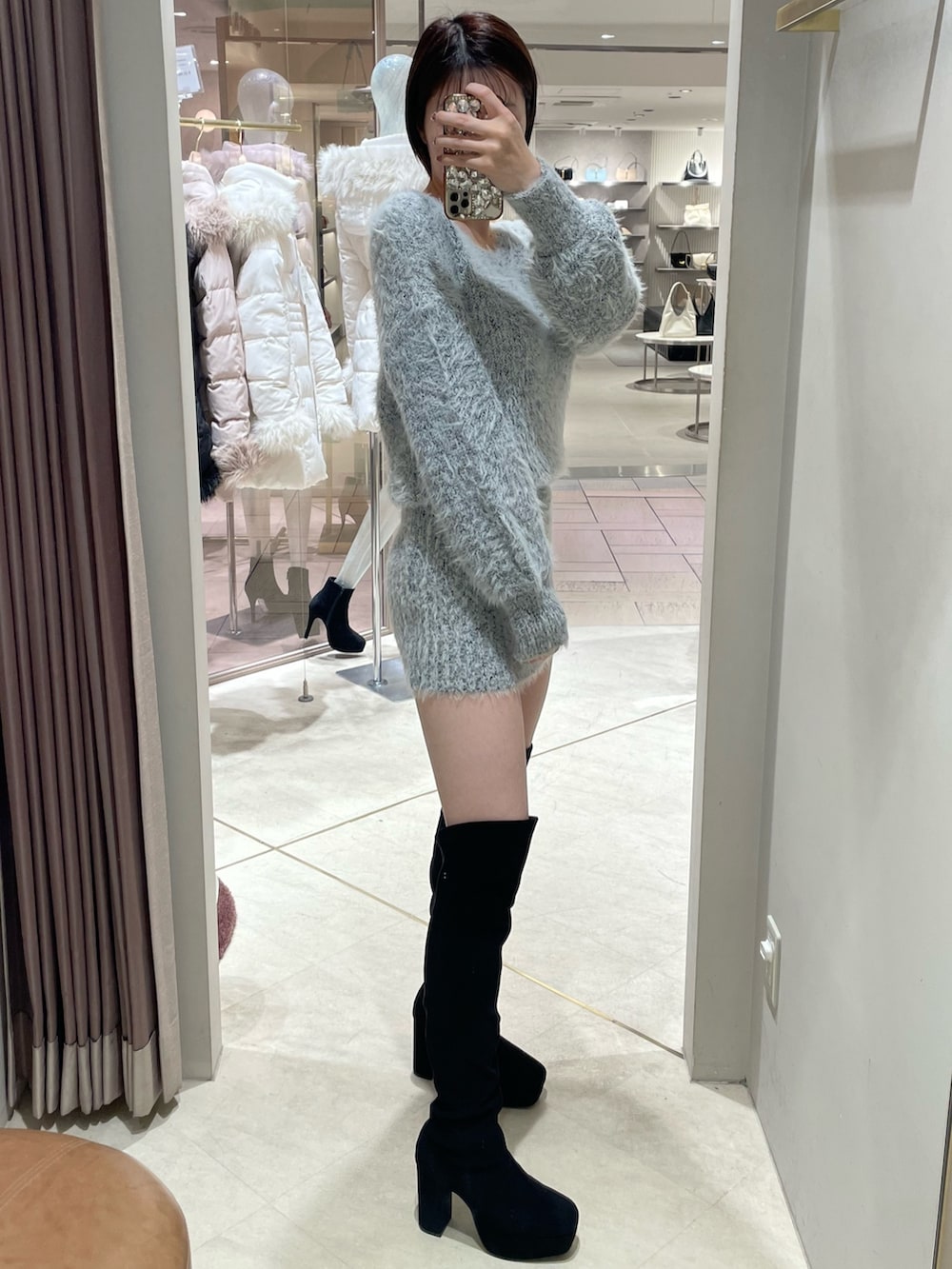 ホワイト系のダウンジャケット/コート、その他のワンピース、ブラック系のブーツを着用したレディースの秋コーディネートの3枚目の写真