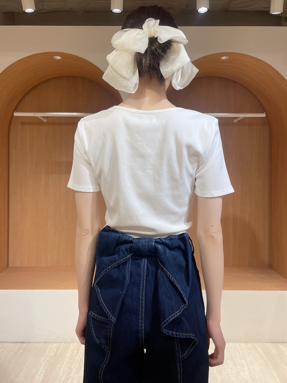 ホワイト系のTシャツ/カットソー、ブルー系のデニムパンツ、ホワイト系のサンダルを着用したレディースの春コーディネートの5枚目の写真