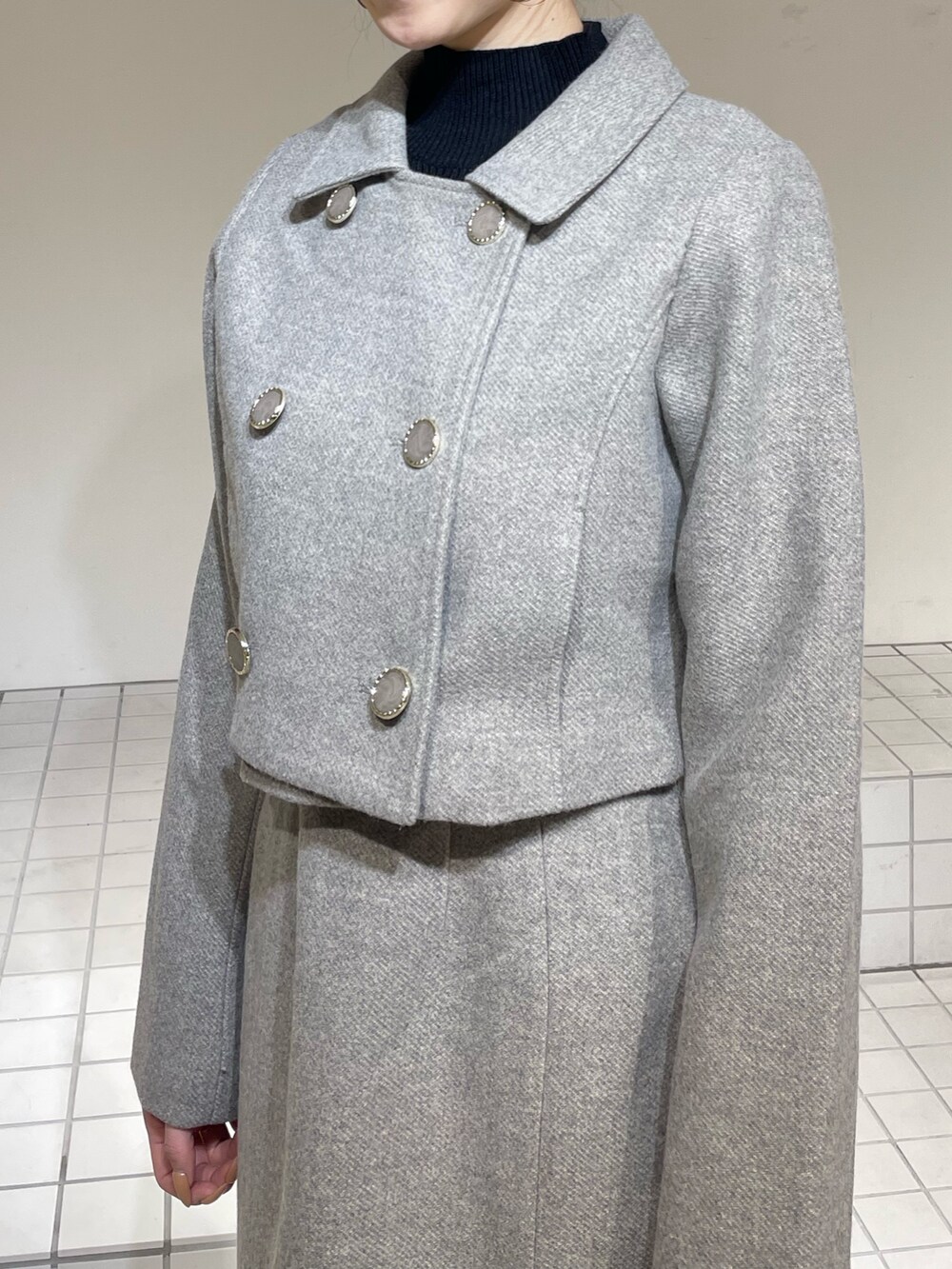 グレー系のその他アウター、グレー系のジャンパースカート、ブラック系のニット/セーターを着用したレディースの冬コーディネートの8枚目の写真