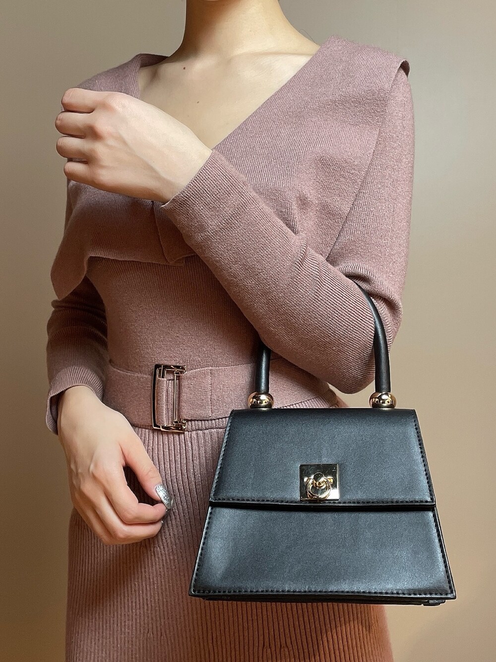 ピンク系のワンピース、ブラック系のハンドバッグ、ブラック系のパンプスを着用したレディースの冬コーディネートの7枚目の写真