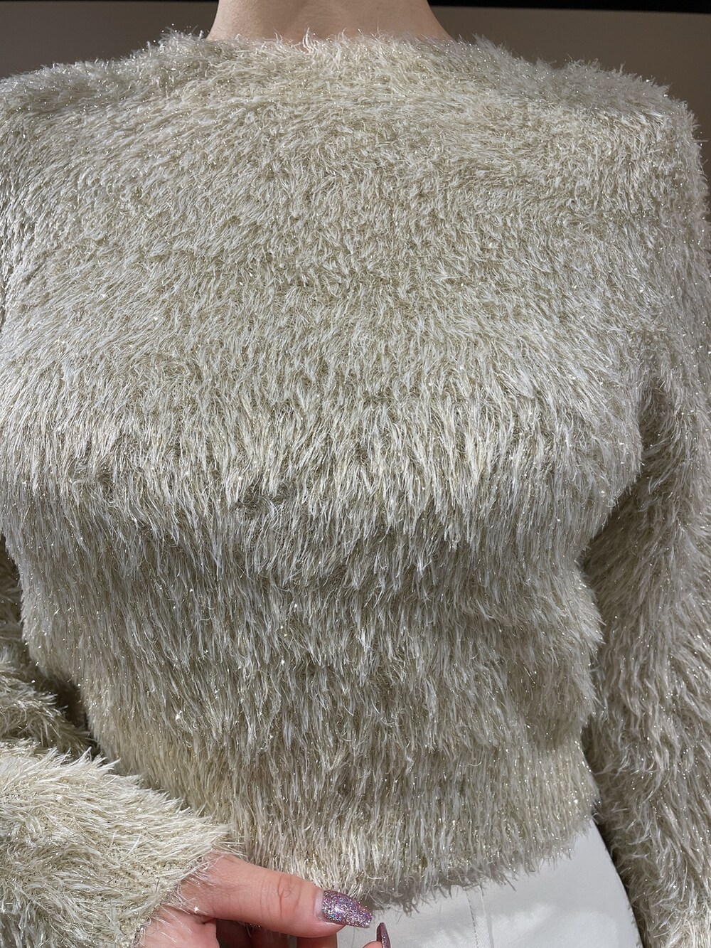 ベージュ系のニット/セーター、ホワイト系のスカート、ホワイト系のブーツを着用したレディースの秋コーディネートの5枚目の写真