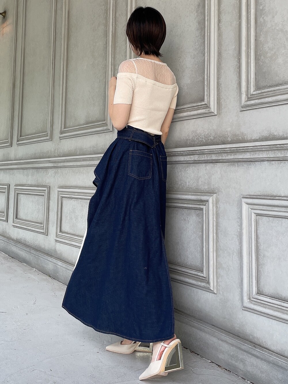 ブルー系のスカート、ホワイト系のニット/セーター、ベージュ系のサンダルを着用したレディースの夏コーディネートの3枚目の写真