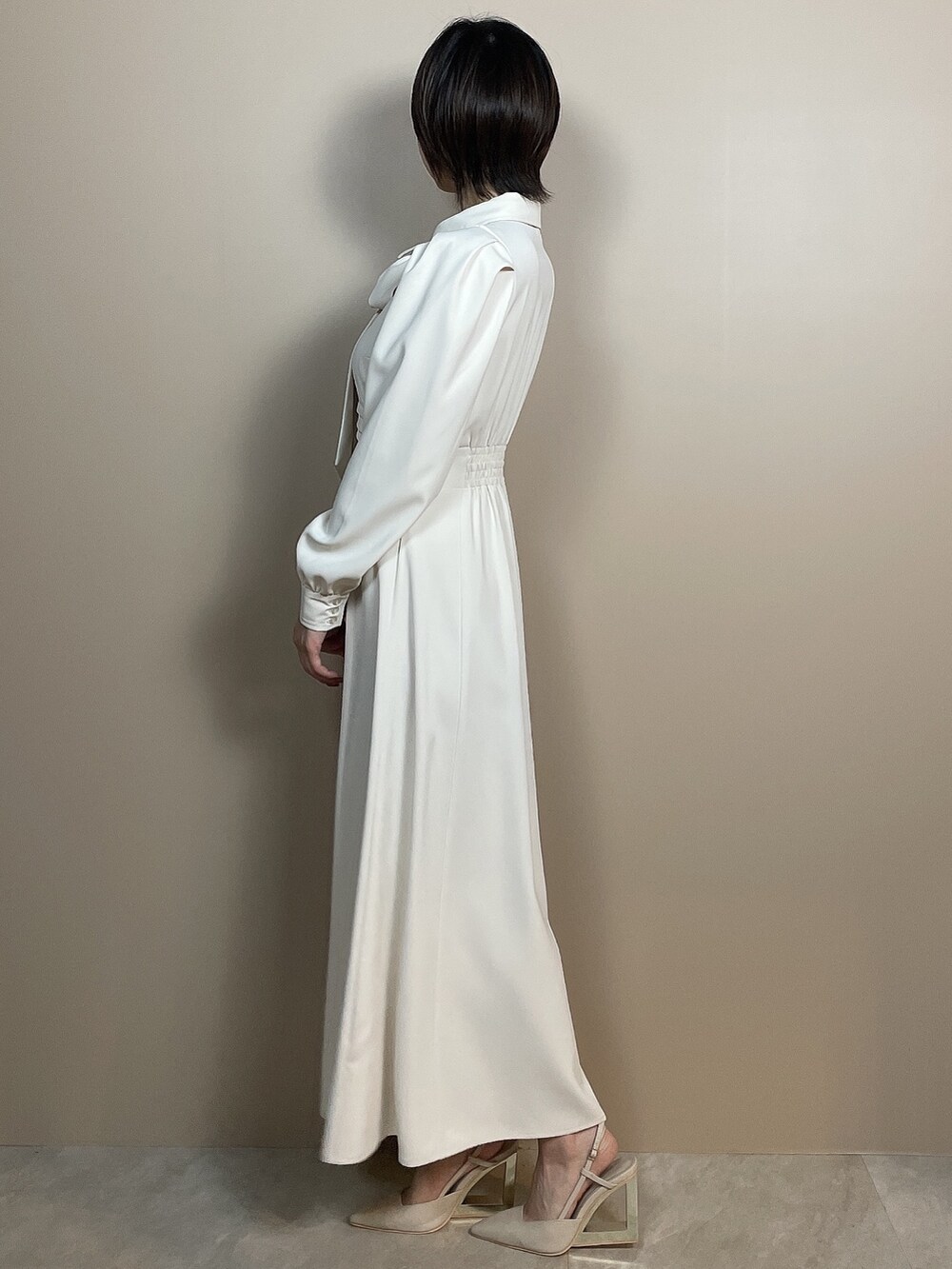 ホワイト系のシャツワンピース、ベージュ系のサンダルを着用したレディースの夏コーディネートの4枚目の写真