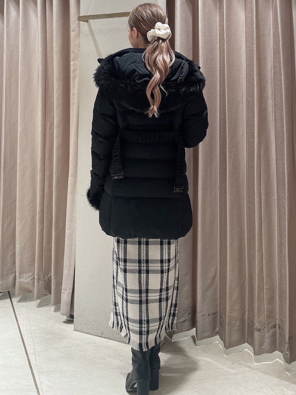 ブラック系のダウンジャケット/コート、グレー系のニット/セーター、ホワイト系のスカートを着用したレディースの秋コーディネートの4枚目の写真