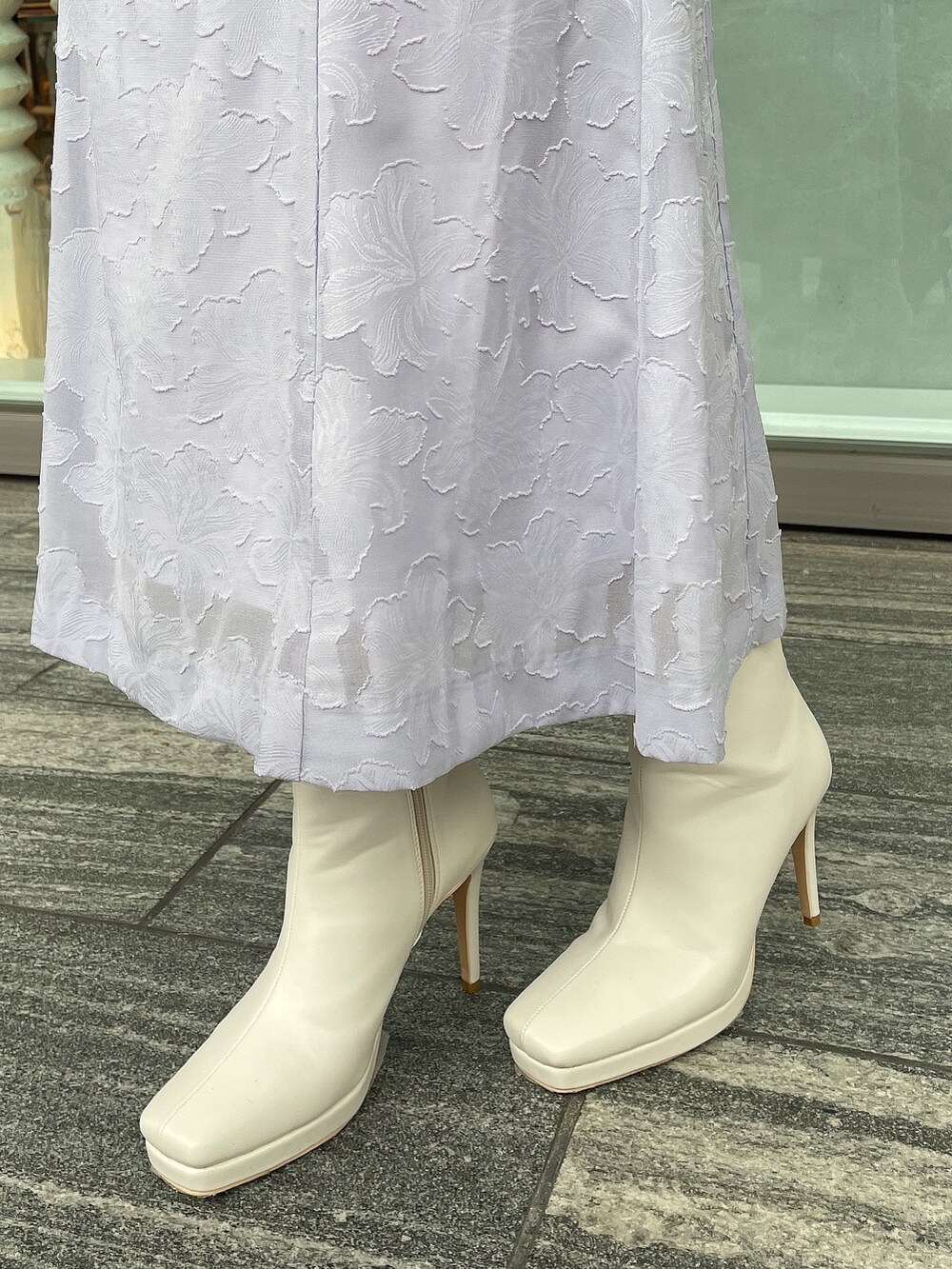 ホワイト系のブーツ、ブラウン系のハンドバッグ、ホワイト系のニット/セーターを着用したレディースの冬コーディネートの7枚目の写真