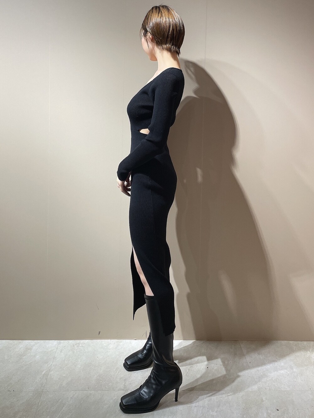 ブラック系のワンピース、ブラック系のダウンジャケット/コート、ブラック系のブーツを着用したレディースの秋コーディネートの2枚目の写真