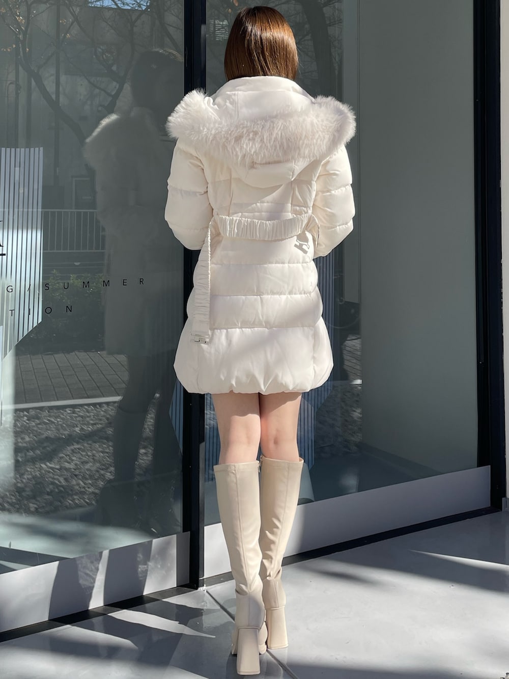 ホワイト系のダウンジャケット/コート、ホワイト系のニット/セーター、ホワイト系のスカートを着用したレディースの冬コーディネートの4枚目の写真