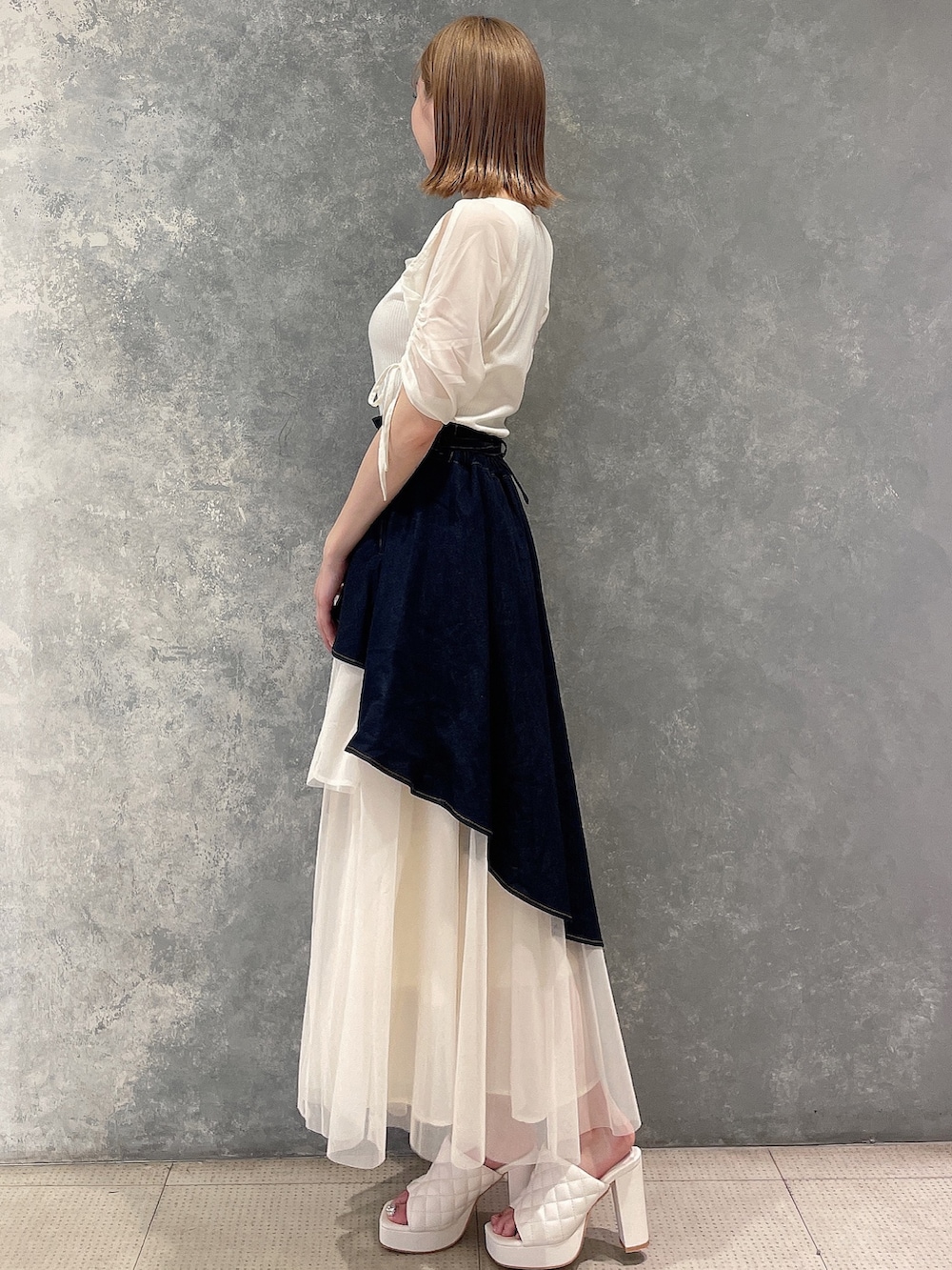 ホワイト系のTシャツ/カットソー、ブルー系のデニムスカート、ホワイト系のサンダルを着用したレディースの夏コーディネートの2枚目の写真