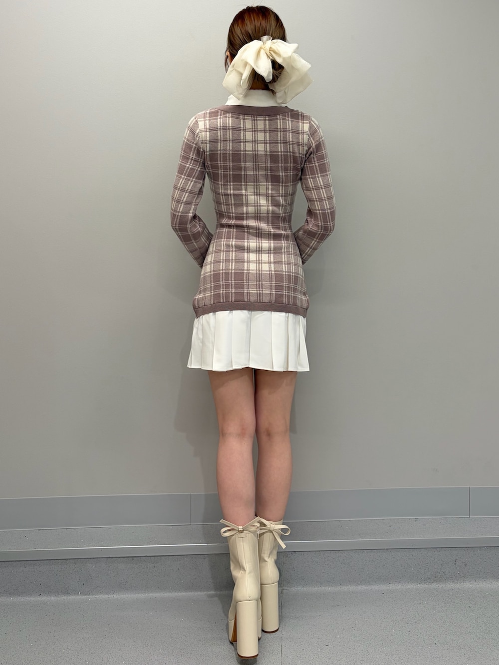 ベージュ系のワンピース、ホワイト系のブーツ、ホワイト系のバレッタ/ヘアクリップを着用したレディースの冬コーディネートの4枚目の写真