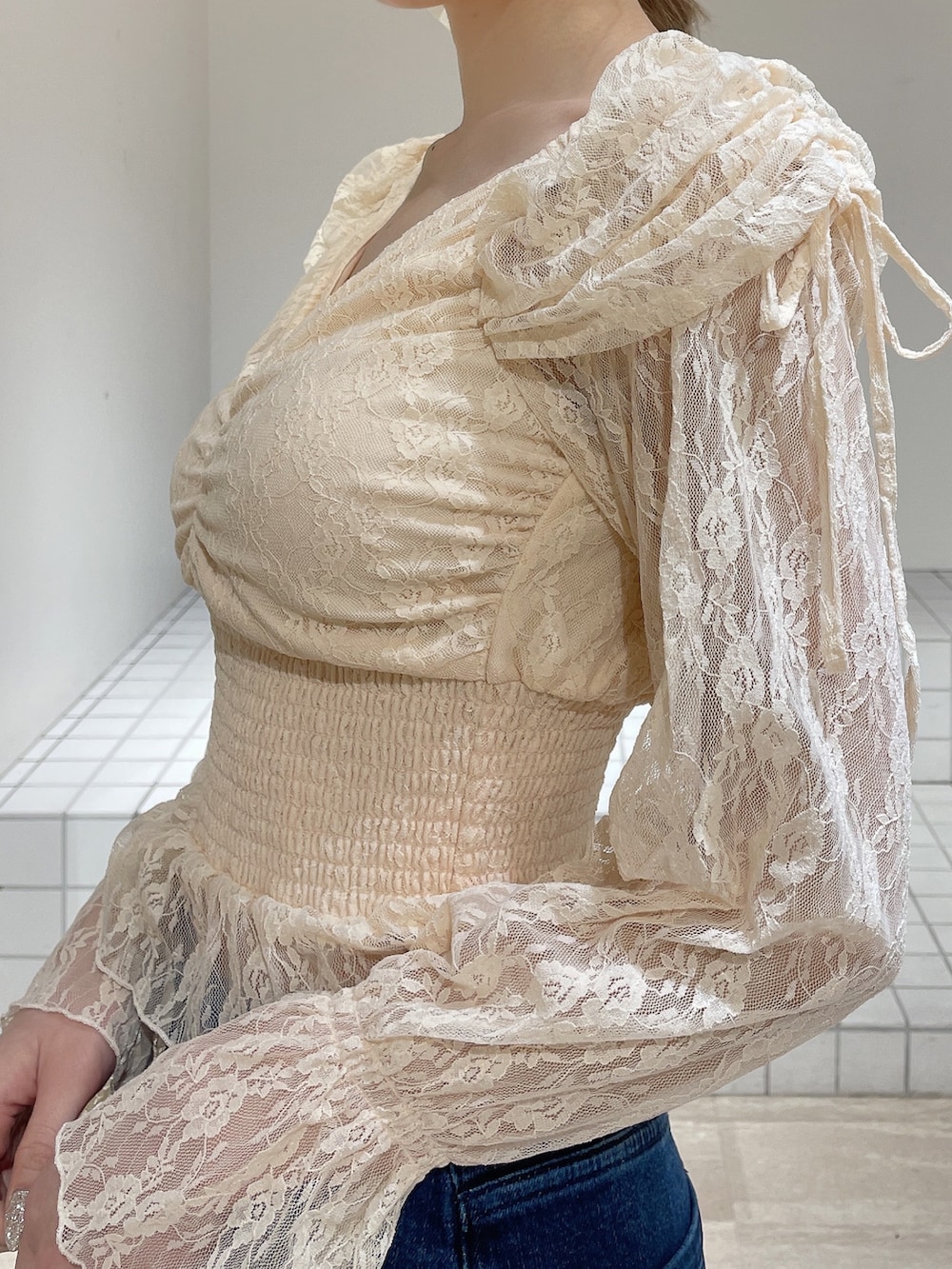 オレンジ系のシャツ/ブラウス、ブルー系のデニムパンツ、ホワイト系のブーツを着用したレディースの春コーディネートの7枚目の写真