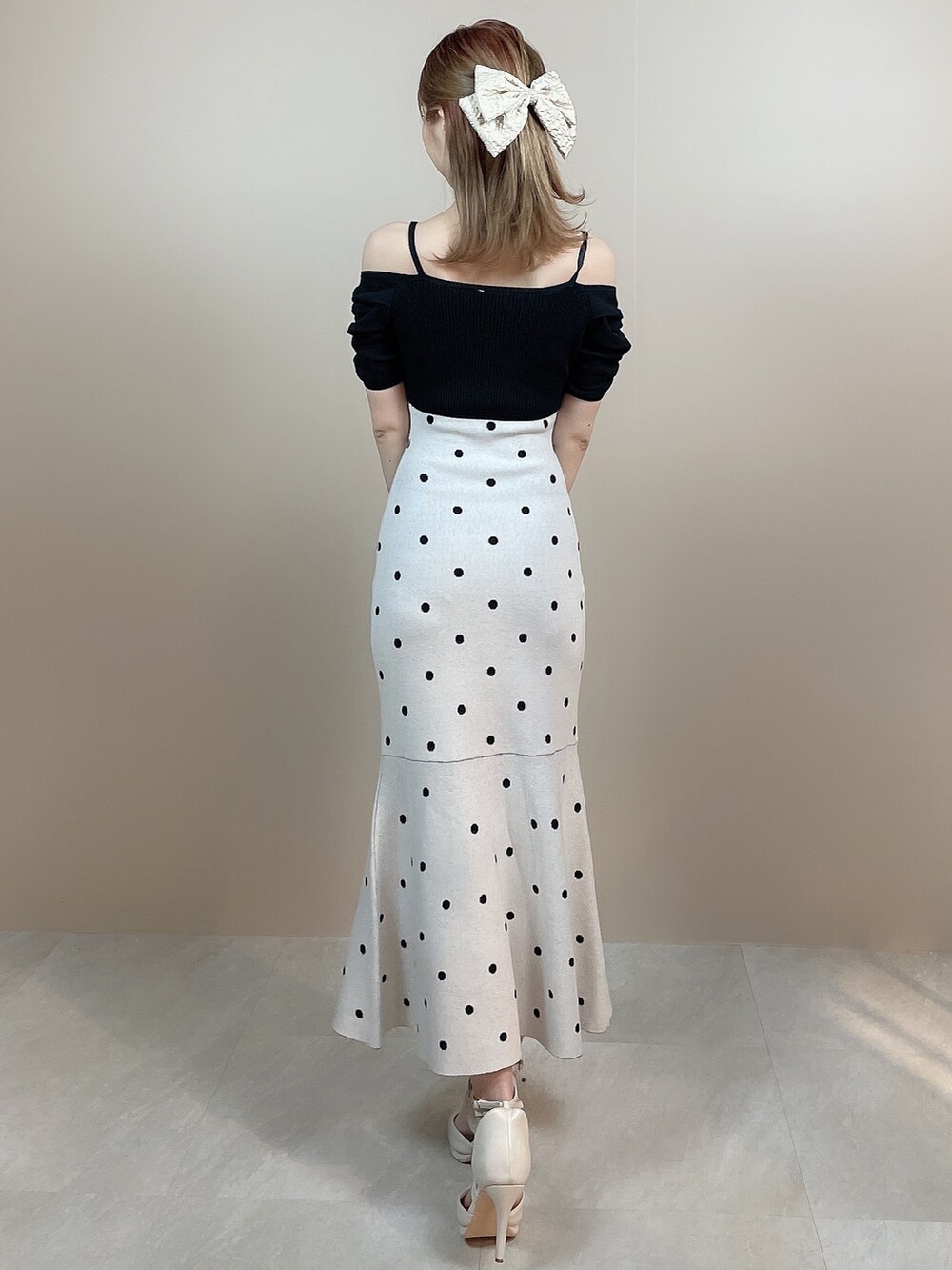 ブラック系のワンピース、ホワイト系のパンプスを着用したレディースの冬コーディネートの4枚目の写真