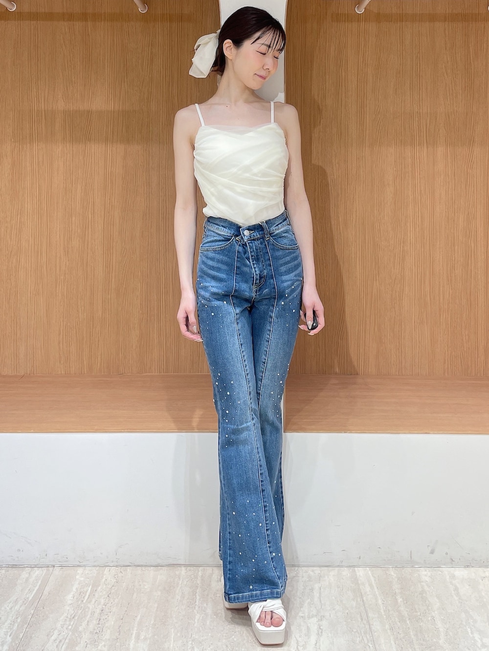 ホワイト系のカーディガン/ボレロ、ブルー系のデニムパンツ、ホワイト系のサンダルを着用したレディースの春コーディネートの4枚目の写真