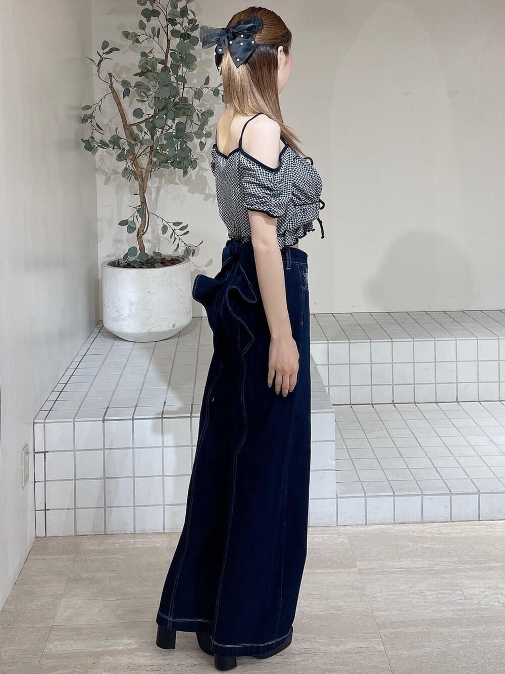 ブラック系のサンダル、ブルー系のデニムパンツ、ブラック系のTシャツ/カットソーを着用したレディースの夏コーディネートの2枚目の写真