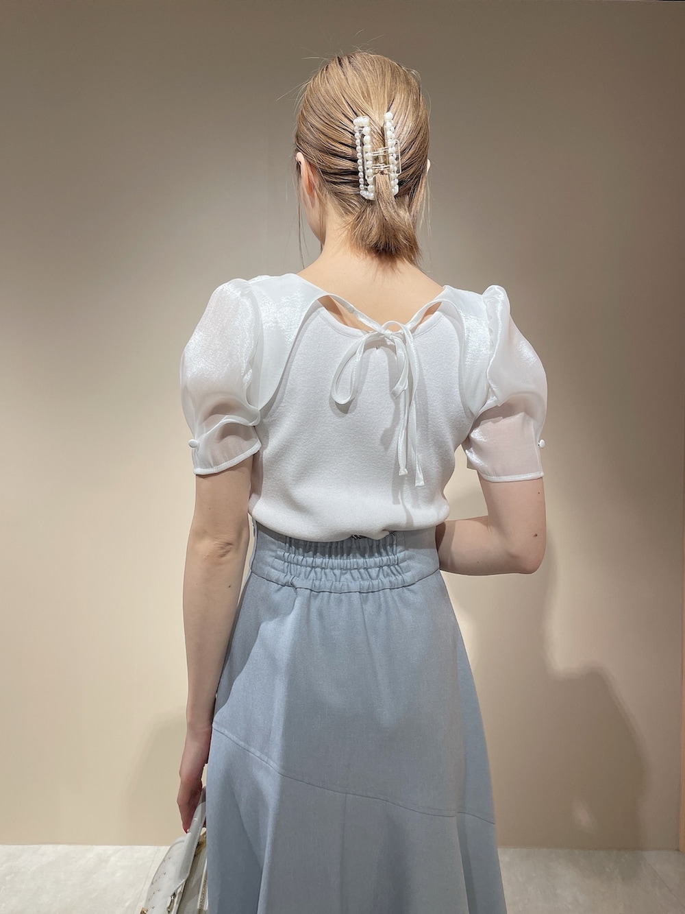 ホワイト系のニット/セーター、ブルー系のスカートを着用したレディースの春コーディネートの7枚目の写真