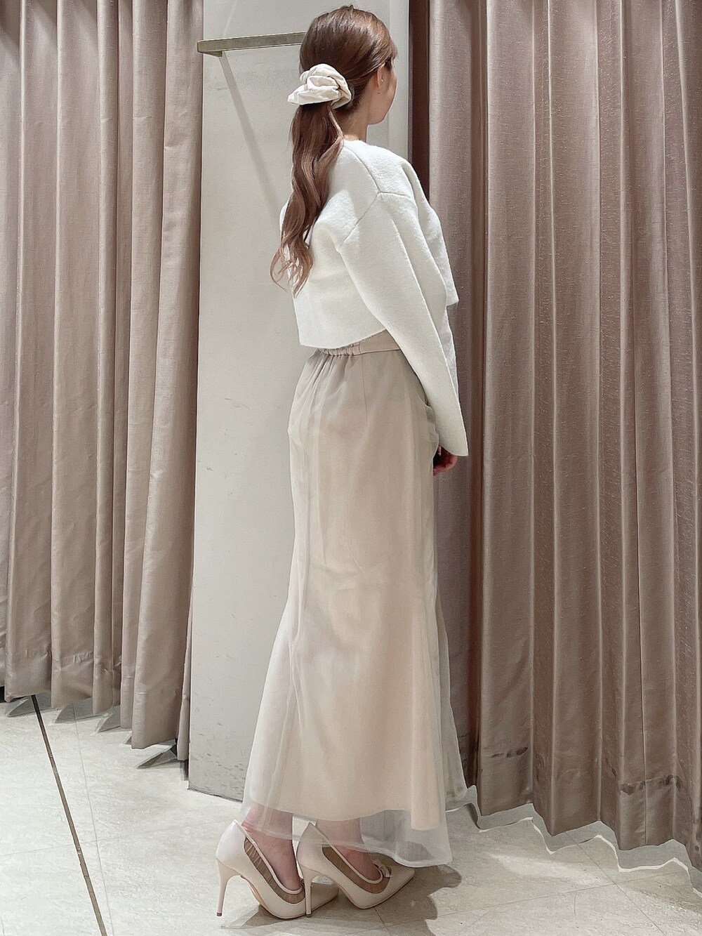ホワイト系のカーディガン/ボレロ、ホワイト系のスカート、ホワイト系のパンプスを着用したレディースの秋コーディネートの3枚目の写真