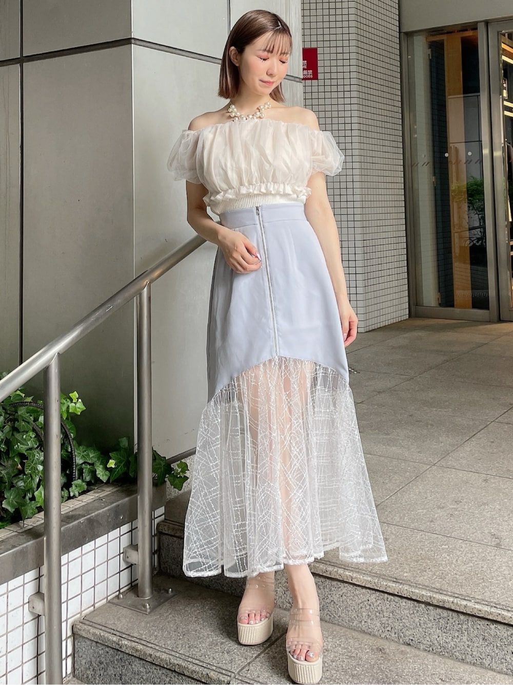 ホワイト系のシャツ/ブラウス、ブルー系のスカート、ホワイト系のサンダルを着用したレディースの夏コーディネートの2枚目の写真